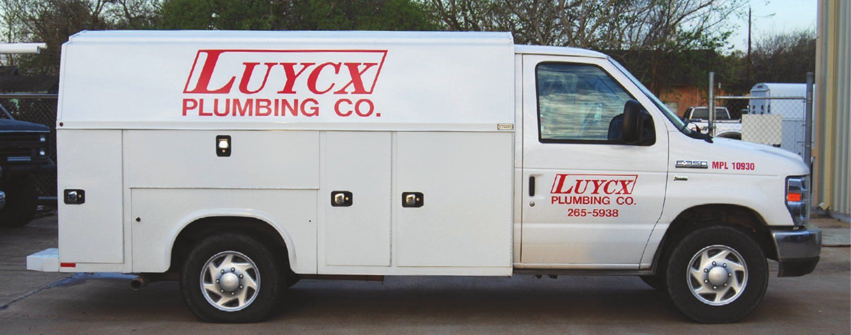 The white Luycx Plumbing Co. service truck with red lettering and the company phone number